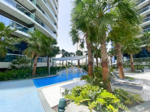 a view of the pool and palm trees in a building at AMAZNING VIEW & PARAMOUNT BRANDED TWO BEDROOM APARTMENTS BRUJ VIEW in Dubai