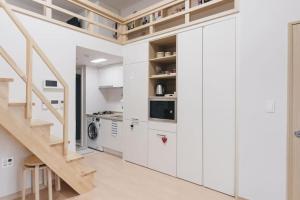 a kitchen with white cabinets and a staircase at LAKE VIEW LOFT JAMSIL in Seoul