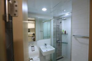Un baño blanco con lavabo y ducha. en LAKE VIEW LOFT JAMSIL, en Seúl 13 fotos más