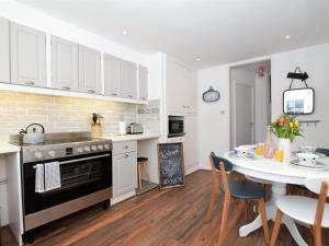 a kitchen and dining room with a table and a stove at 2 Bed in Widemouth Bay 55833 in Marhamchurch