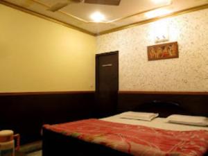 Hotel Ajay International Agra في آغْرا: غرفة بها سرير وبطانية حمراء