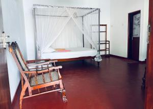 1 dormitorio con cama y mecedora en Ranmitha Villa, en Weligama