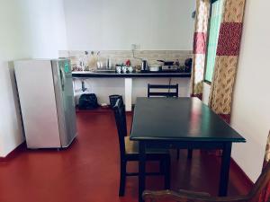 cocina con mesa y nevera en Ranmitha Villa, en Weligama