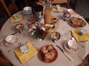 einen Tisch mit Teller mit Lebensmitteln und Blumen darauf in der Unterkunft La Maison d'Andrée in Pluvet