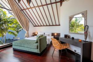 a bedroom with a bed and a desk and a couch at Villa Tramonto By Le Cielo in Canggu