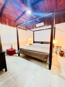 a bed in a room with a wooden ceiling at Perro Loco Villas in Paraíso