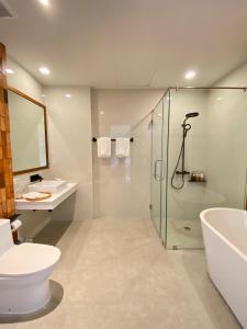 y baño con ducha, aseo y lavamanos. en Punn Hotel Korat en Nakhon Ratchasima