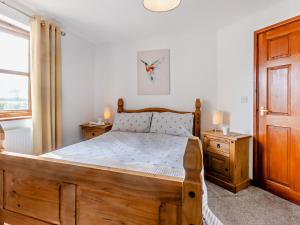 een slaapkamer met een houten bed en een raam bij 2 Bed in Bude 51764 in Pyworthy