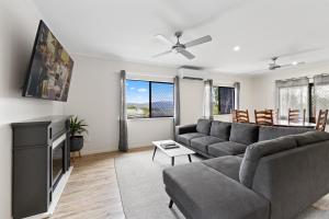 a living room with a couch and a tv at Highview Atherton in Atherton