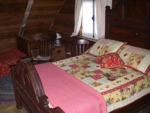 a bedroom with a large bed with a pink blanket at Au Vieux Foyer in St-Pierre-de-l'Île-d'Orléans