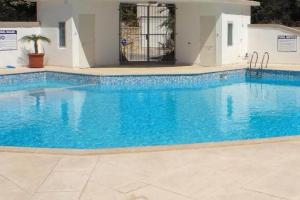 une grande piscine d'eau bleue dans l'établissement Apartment in Swieqi with communal pool, à Tal-Għoqod