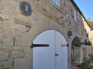 Stocksfield的住宿－3 bed in Hexham 32252，石屋,有白色的门和拱门