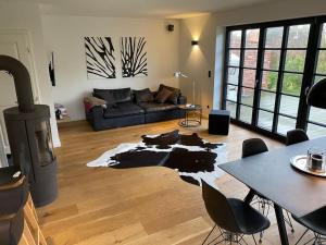 a living room with a cow rug on the floor at Reetdachhaus bei St Peter-Ording - Tating in Tating