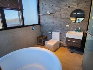 五結鄉的住宿－一田一墅 民宿，浴室配有白色卫生间和盥洗盆。