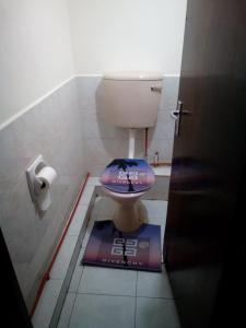 a bathroom with a toilet with a sign on the floor at Pritanier in Flic-en-Flac