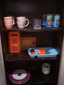 a wooden shelf with cups and plates on it at Pritanier in Flic-en-Flac