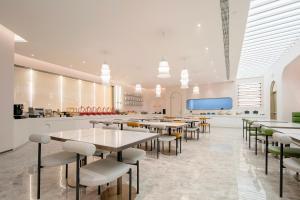 a restaurant with tables and chairs in a cafeteria at Atour Hotel Shanghai Lujiazui Pudong Avenue in Shanghai