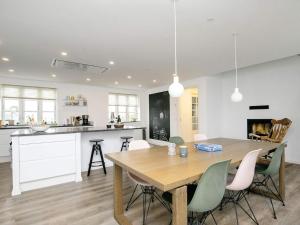 uma cozinha e sala de jantar com uma mesa de madeira e cadeiras em Holiday home Bogense XXVI em Bogense