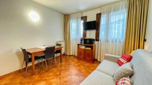 ein Wohnzimmer mit einem Sofa und einem Tisch mit einem Schreibtisch in der Unterkunft Appartamento Smith Dogliani - Affitti Brevi Italia in Bardonecchia