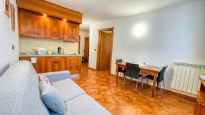 ein Wohnzimmer mit einem Sofa und einem Tisch sowie eine Küche in der Unterkunft Appartamento Smith Dogliani - Affitti Brevi Italia in Bardonecchia