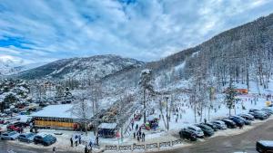 eine Gruppe von Autos, die auf einem Parkplatz im Schnee geparkt sind in der Unterkunft Appartamento Smith Dogliani - Affitti Brevi Italia in Bardonecchia