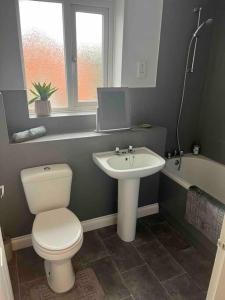 a bathroom with a toilet and a sink and a tub at Nuneaton-GE Hospital 3 mins away in Nuneaton