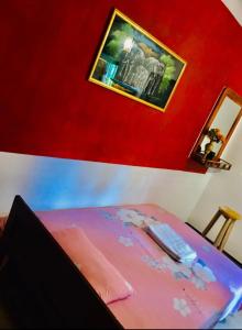 - une chambre dotée d'un lit rose avec une photo murale dans l'établissement Charitha Rest, à Ampara