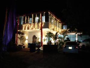 a house lit up at night with christmas lights at Tharuka Rest Inn Hotel in Tanamalwila