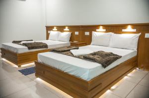 Emerald Royal Residency في كوتشي: سريرين في غرفة مع إضاءة عليهم