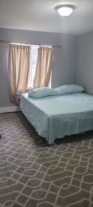 a bed in a room with a window and a bed sidx sidx at Room in a Beach House with King Size bed in a landlord hosted three bedroom apartment in Edgemere