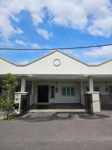 une maison blanche avec ses portes s'ouvrant sur une rue dans l'établissement Air-home No 28 Simpang near Aulong Econsave, 3BR, 7pax, Netflix, à Simpang