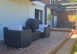 un patio con 2 sedie in vimini e una griglia di Ravensdale Vista a Christchurch