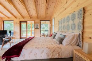 a bedroom with a large bed in a wooden cabin at It's Bonza! at Mill About Vineyard in Williamstown