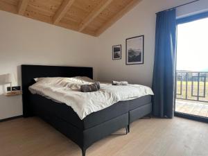 a bed in a bedroom with a large window at Chalet in Hermagor with nice views and sauna in Hermagor