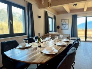 a large wooden table with chairs and a bottle of wine at Chalet in Hermagor with nice views and sauna in Hermagor