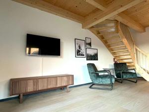a living room with two chairs and a tv on a wall at Chalet in Hermagor with nice views and sauna in Hermagor