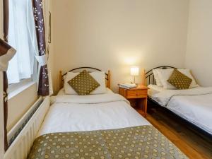 Habitación con 2 camas, mesa y ventana en 3 Bed in Nantgaredig 56410 en Llanfynydd