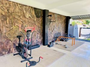 a room with two exercise bikes and a stone wall at Lumbung Seraya Villa in Karangasem