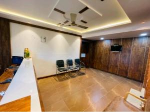 a meeting room with two chairs and a ceiling at Yashaswiny recidency in Mysore