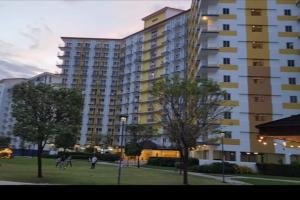 a large apartment building with people in a park at Azul Condo 2 bedroom Manila in Manila