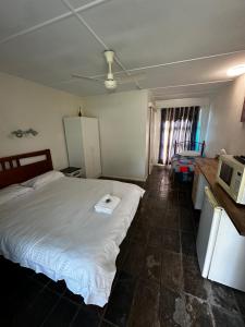 1 dormitorio con cama blanca y microondas en Colosseum Creek Motel, en Colosseum