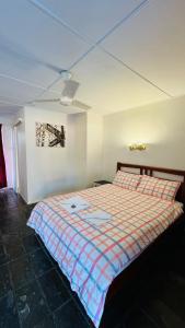 a bedroom with a bed with a checkered blanket at Colosseum Creek Motel in Colosseum