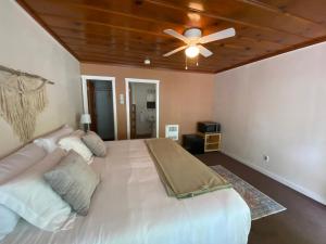 a large bed in a bedroom with a ceiling fan at Seven Circles Lodge&Retreat in Badger