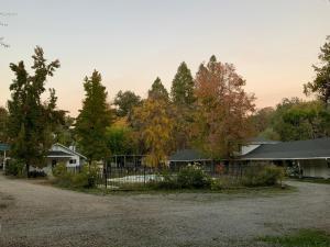una valla frente a una casa con árboles en Seven Circles Lodge&Retreat en Badger