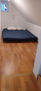 a bed in a room with a wooden floor at Zimmer auf dem Land in Sankt Margarethen an der Raab