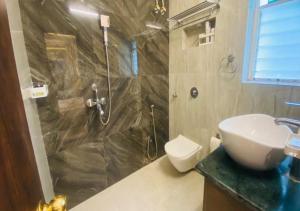 a bathroom with a shower and a sink and a toilet at One Infinity Residency in kolkata