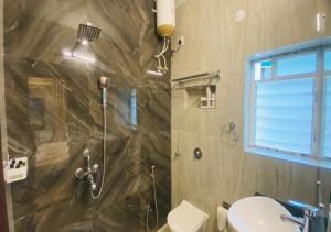 a bathroom with a shower and a toilet at One Infinity Residency in kolkata