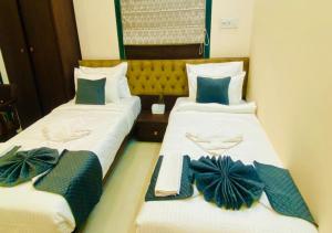 two beds in a hotel room with bow ties on them at One Infinity Residency in kolkata