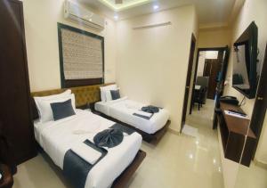 a hotel room with two beds and a desk at One Infinity Residency in kolkata