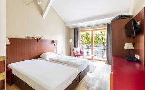 - une chambre avec un lit, une télévision et une fenêtre dans l'établissement Hotel Fährhaus GmbH, à Woltersdorf